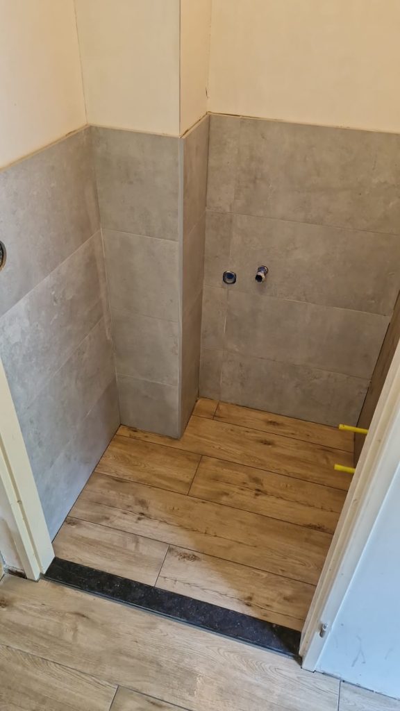Nieuwe badkamer met betegelde muren en vloer