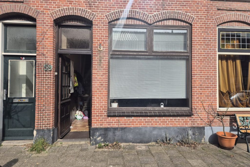 Voordeur roodstenen huis met nummer 59.